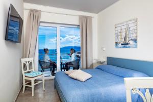 a bedroom with a bed and a window with a view at La casa del pescatore in Cala Gonone