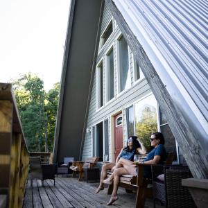 two women sitting on the porch of a house at Fallswood Lodge - by The Chalets in Logan +38 photos