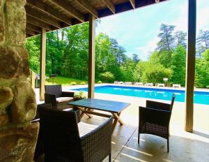 a patio with a table and chairs and a pool at Fireside Lodge - by The Chalets in Logan