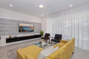 a living room with a yellow couch and a tv at Luxurious Townhome in Solterra Resort - SOLT01 in Davenport