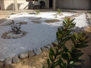 un giardino con rocce e piante in un cortile di Pisceneris Holiday Home a Uras