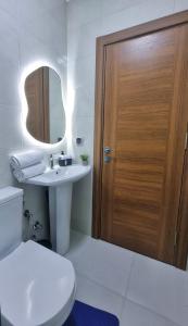BerrechidにあるCosy Stay 15min from Casablanca Airport, in Berrechidのバスルーム(トイレ、シンク付)、木製のドアが備わります。 +9枚の写真