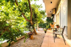 un patio con mesa, sillas y árboles en Central House of Ialisos, en Ialisos