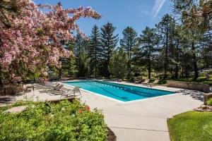 a swimming pool in a yard with chairs and trees at Red Pine By Park City Vacations in Park City