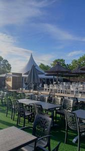 a group of tables and chairs with umbrellas at Mobilhome 8 personnes Camping 4 étoiles Vias plage - la Carabasse in Vias +25 photos