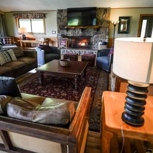a living room with a couch and a fireplace at Grande Butte Lodge - by The Chalets in Laurelville