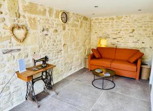 a living room with an orange couch and a table at Le gîte 24 proche du Futuroscope - Jacuzzi compris in Beaumont