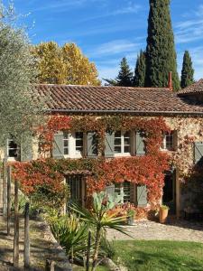 a brick house with red leaves on it at Le Mas du Naoc in Cabris