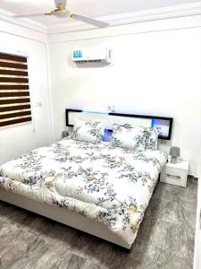 a bedroom with a bed with a floral bedspread at Kan's Krib in Accra
