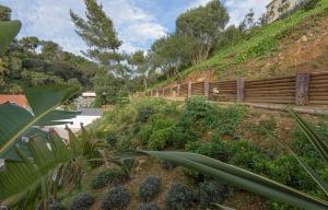 a wooden fence on a hill with plants at Estoril Village Guest House in Estoril