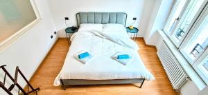a bedroom with a bed with two books on it at NEL CUORE DEL FESTiVAL -fascino anni '50 con balcone in centro storico- in Trento