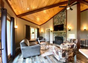 a living room with couches and a stone fireplace at Lakeview - by The Chalets in Logan
