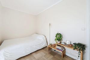 a bedroom with a bed and a table with plants at Charming quiet apartment near Disney in Fontenay-sous-Bois +4 photos
