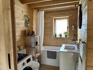 a small bathroom with a tub and a sink at Cabane de Mardil in Aubazines