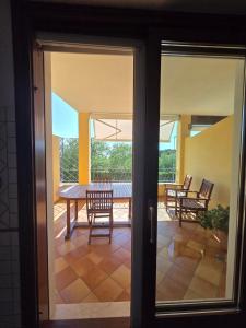 a glass door leading to a patio with a table and chairs at La Casetta al Lido in Alghero
