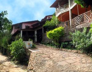 a house with a stone path in front of a building at Pousada Casa De Helia in Lençóis