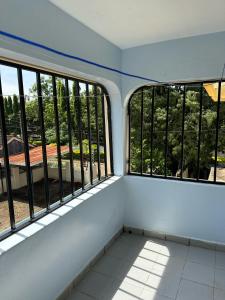 a train room with windows and a balcony at Ecostay fair two bedrooms in Kisumu