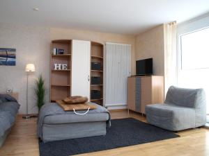 a living room with a couch and a chair at Haus Sonnenhaken Wohnung 1 in Norderney