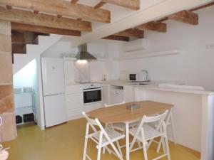 a kitchen with a wooden table and white appliances at Andrones in Ciutadella