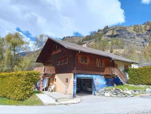 a large wooden house with a mountain in the background at Le chemin des étoiles in Evolène