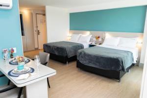 pokój hotelowy z dwoma łóżkami i stołem w obiekcie 202 Flat Beira Mar Av Boa viagem - Vista para o mar w mieście Recife +38 zdjęć