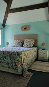 a bedroom with a bed with a floral bedspread and two lamps at Les Murmures de Charente in Villiers-le-Roux