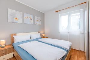 a bedroom with a bed with blue and white sheets at Kuća Koza-Apartment Marijana in Punat +32 photos