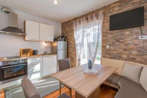 a kitchen with a wooden table in a room at Kuća Koza-Apartment Marijana in Punat