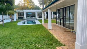 a house with a swimming pool in the yard at Central Perk Guesthouse in Pretoria