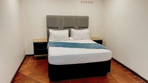 a bedroom with a bed with a large headboard at Central Perk Guesthouse in Pretoria +30 photos