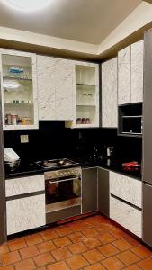 a kitchen with black and white cabinets and an oven at Central Perk Guesthouse in Pretoria