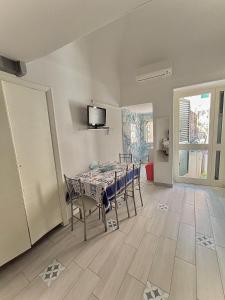 a dining room with a table and chairs and a television at Cantone Studio On The Beach in Cetara
