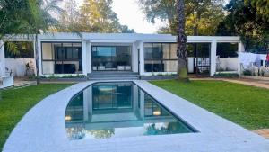 a house with a swimming pool in the yard at Central Perk Guesthouse in Pretoria