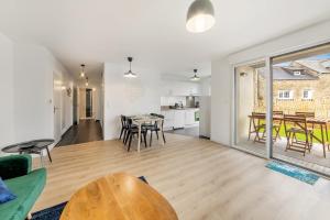 a living room and kitchen with a table and chairs at Bella Vista - Appartement 2 Chambres Moderne et Confortable in Saint-Coulomb