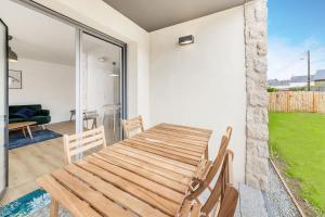 a dining room with a wooden table and chairs at Bella Vista - Appartement 2 Chambres Moderne et Confortable in Saint-Coulomb
