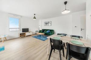 a living room with a table and chairs and a couch at Bella Vista - Appartement 2 Chambres Moderne et Confortable in Saint-Coulomb +12 photos