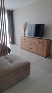 a living room with a flat screen tv on a wooden cabinet at DNV Apartments 30 Varna in Varna City