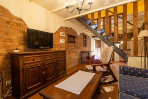 a living room with a tv and a couch and a table at La Casona del Cura 2, LIRIO in Pravia +8 photos
