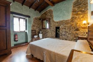 a bedroom with a bed and a stone wall at La Casona del Cura 2, LIRIO in Pravia