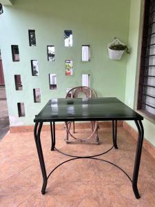 a black table and a chair in front of a wall at Bush and Forest Safari Retreat in Arusha