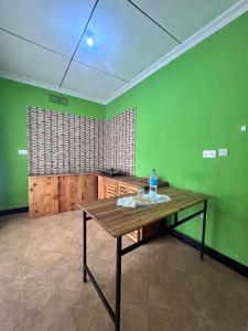 a wooden table in a room with green walls at Bush and Forest Safari Retreat in Arusha +16 photos