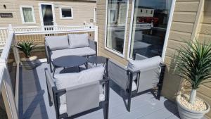a patio with two chairs and a table on a porch at Coastal Retreat Lodge in Morecambe