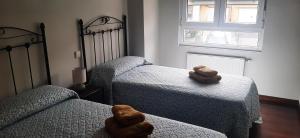 two beds in a bedroom with two teddy bears at El Gallo Azul in Oruña