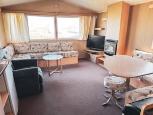 a living room with a couch and a table at Beachside Caravan Retreat In Lowestoft Sleeps 6 in Lowestoft