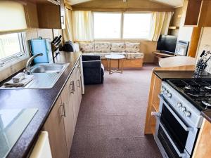 a kitchen with a sink and a stove top oven at Beachside Caravan Retreat In Lowestoft Sleeps 6 in Lowestoft +13 photos