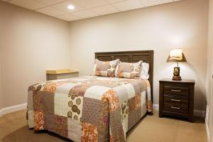 a bedroom with a bed and a lamp on a night stand at Treetop - by The Chalets in Logan