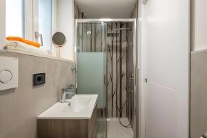 a bathroom with a sink and a shower at Favola Rosa in Alghero +32 photos