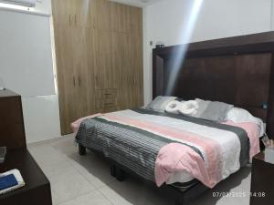 a bedroom with a bed with two white towels on it at Casa Montiel in Mérida