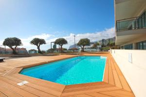 uma piscina num deque de madeira ao lado de um edifício em Monumental Residence apartment with pool by HR Madeira no Funchal