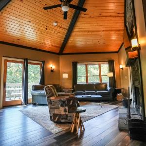 a living room with leather furniture and a wooden ceiling at Treetop - by The Chalets in Logan +14 photos